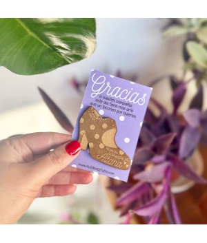 Detalle de comunión original de estilo flamenco presentado sobre mesa de madera rústica y flores de paniculata